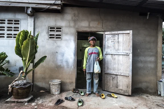 Reisbauer mit Tüte steht in einer Holztür in Thailand