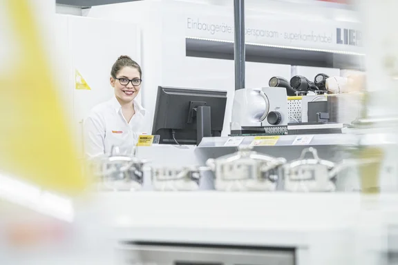 Frau mit Brille steht an einem Computer