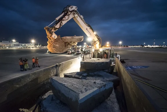 Bagger der Betonteile versetzt, bei Nacht