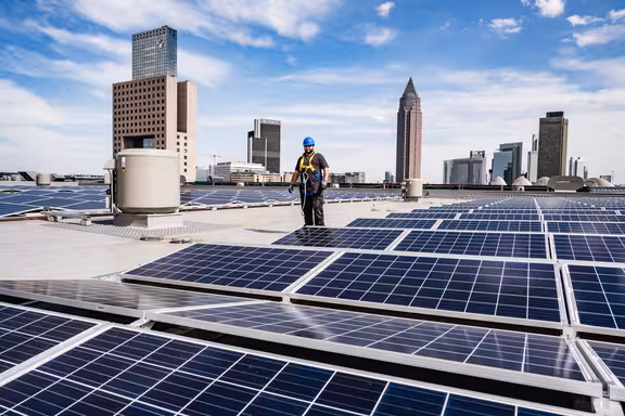 Arbeiter auf einem Dach mit vielen Photovoltaikanlagen
