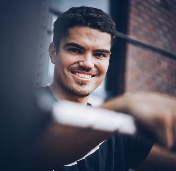 Mann mit schwarzen Haaren und Bart, Vordergrund unscharf