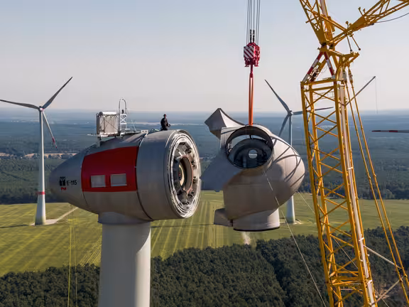 Windrad, an das mit einem Kran ein Teil angebaut wird