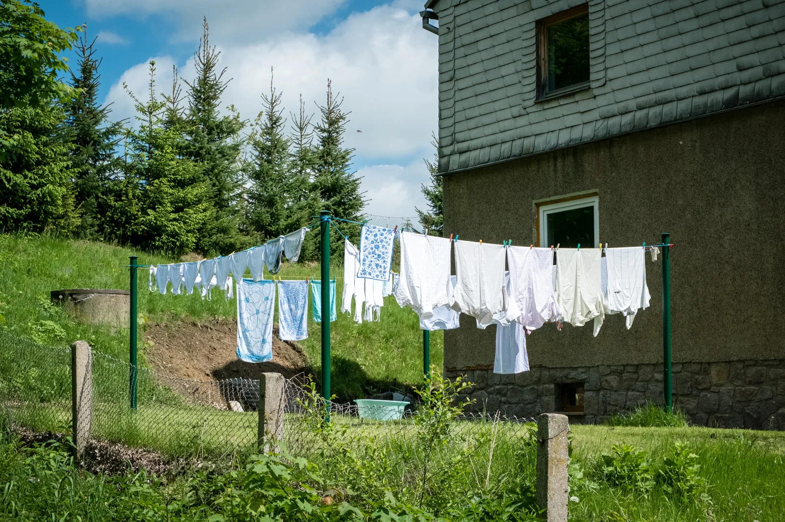 Wäsche hinter einem Haus auf einer Wäscheleine im Garten