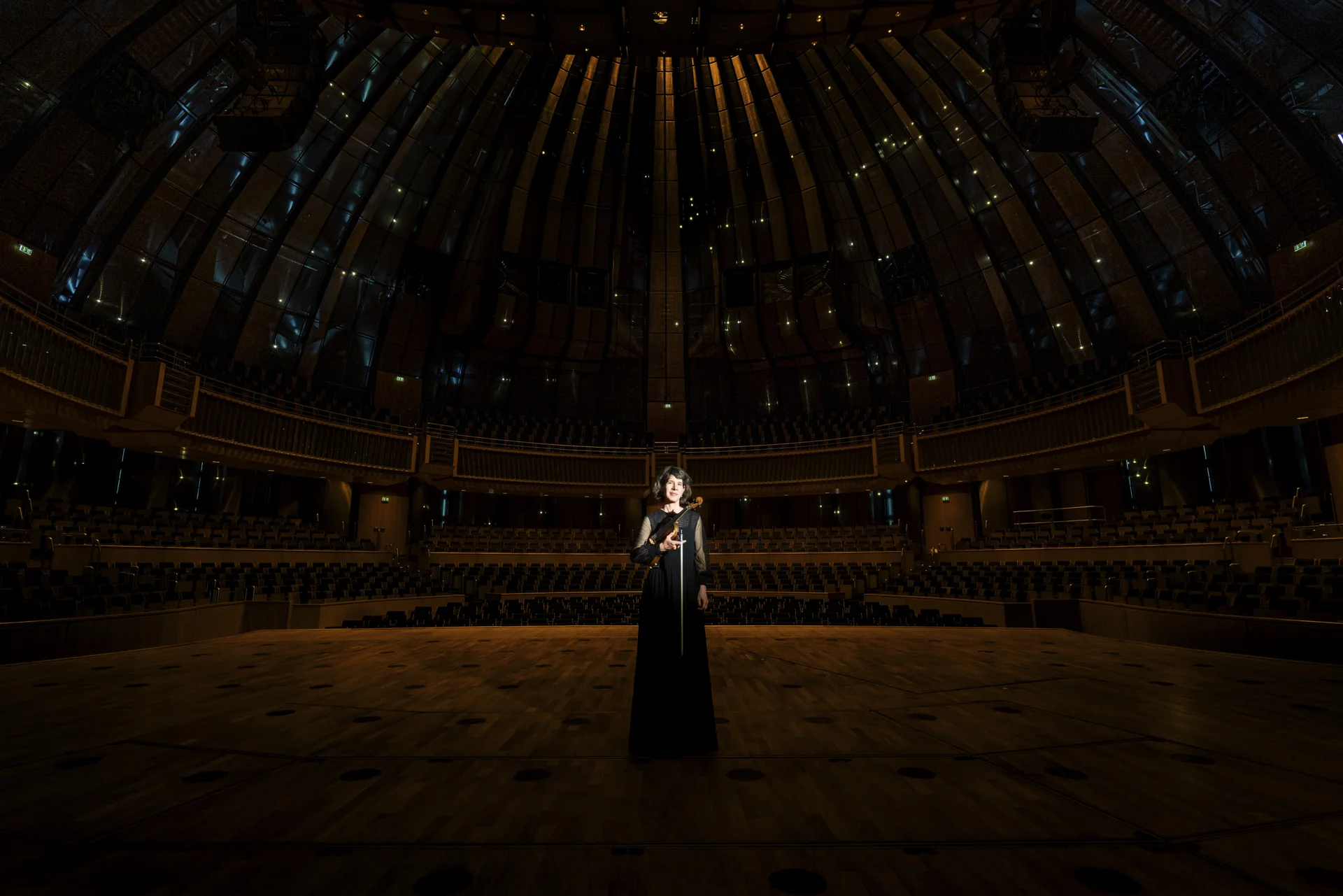 Lichtspot auf Person im Kleid in der Mitte eines Konzertsaals