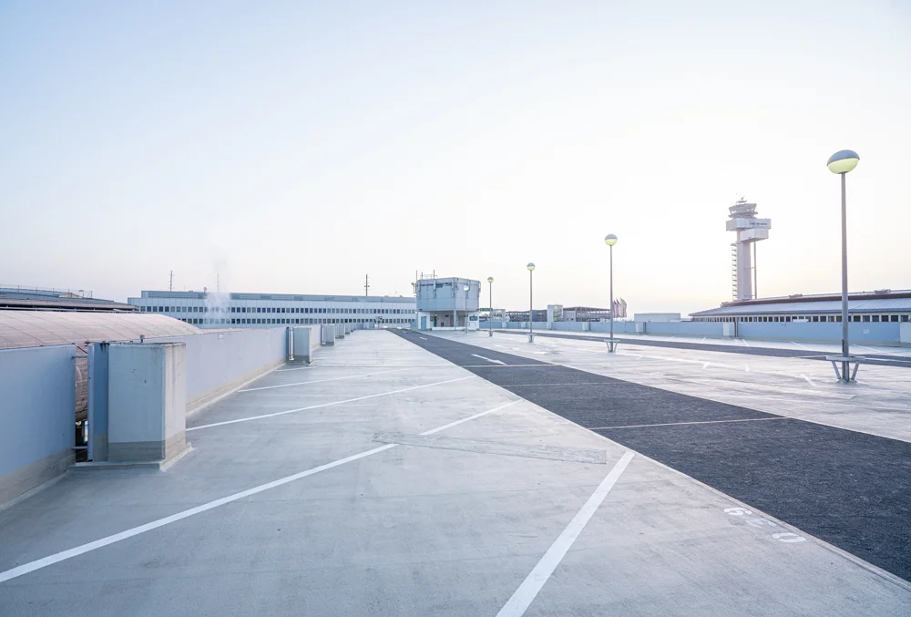 leerer Parkplatz mit Flughafengebäude im Hintergrund