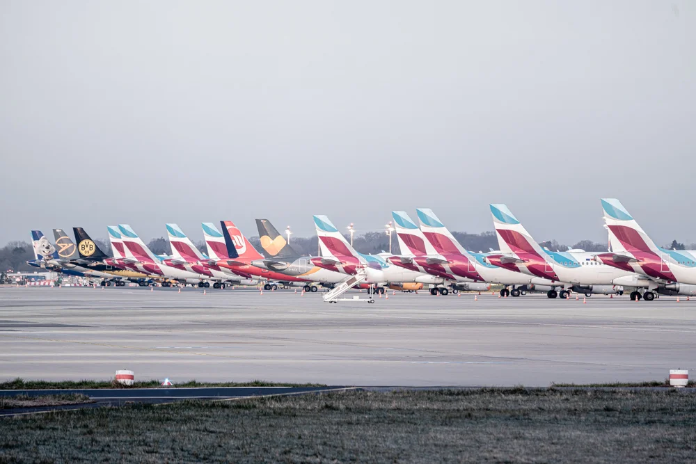 Rollfeld mit mehreren Flugzeugen in einer Reihe