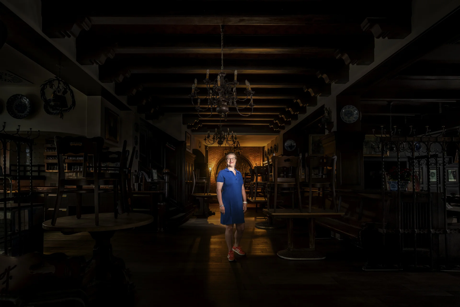 Frau in blauem Kleid in einer leeren Gaststätte, dunkel Lichtspot in der Mitte auf der Frau