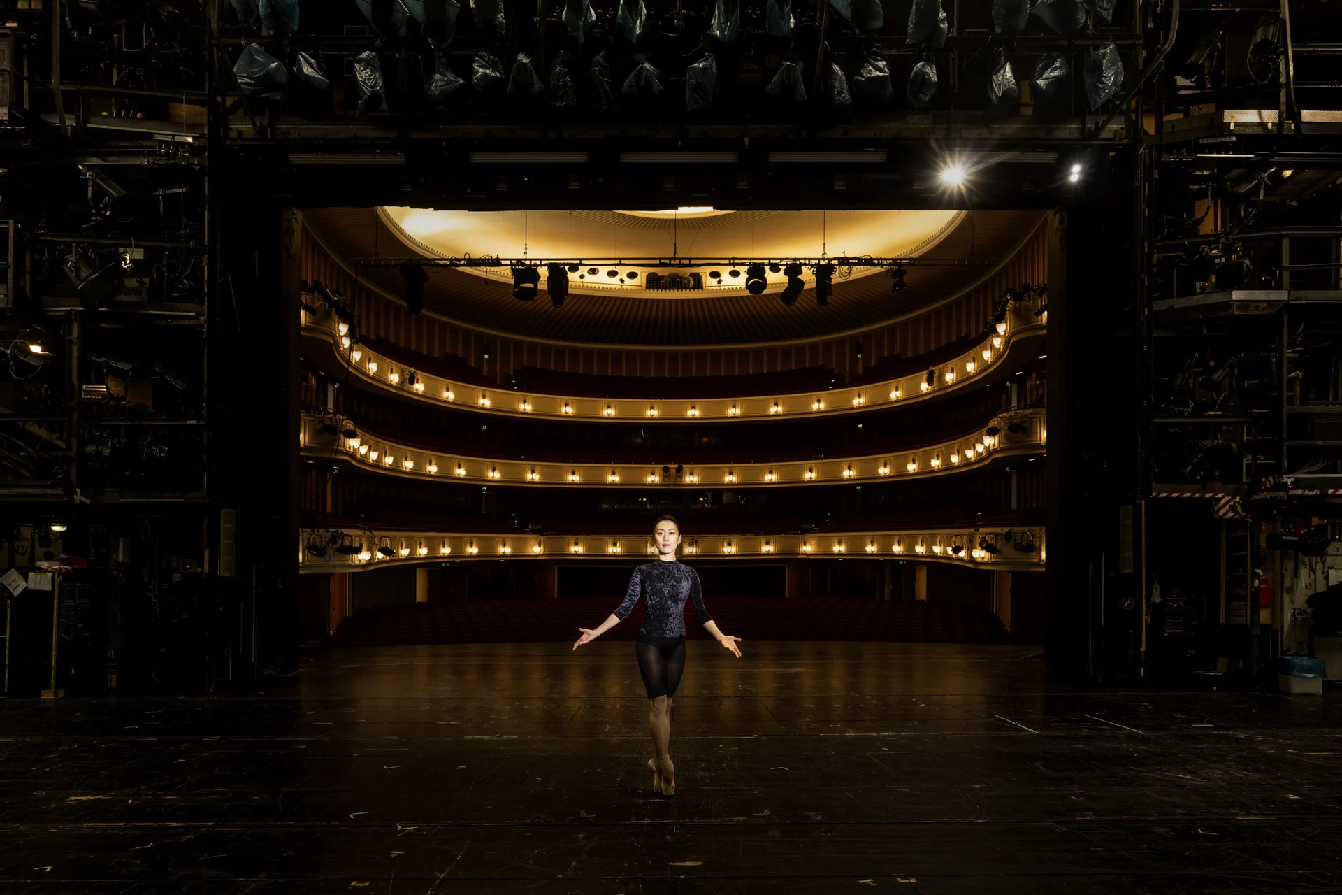 Lichtspot auf Frau in der Mitte einer leeren Oper