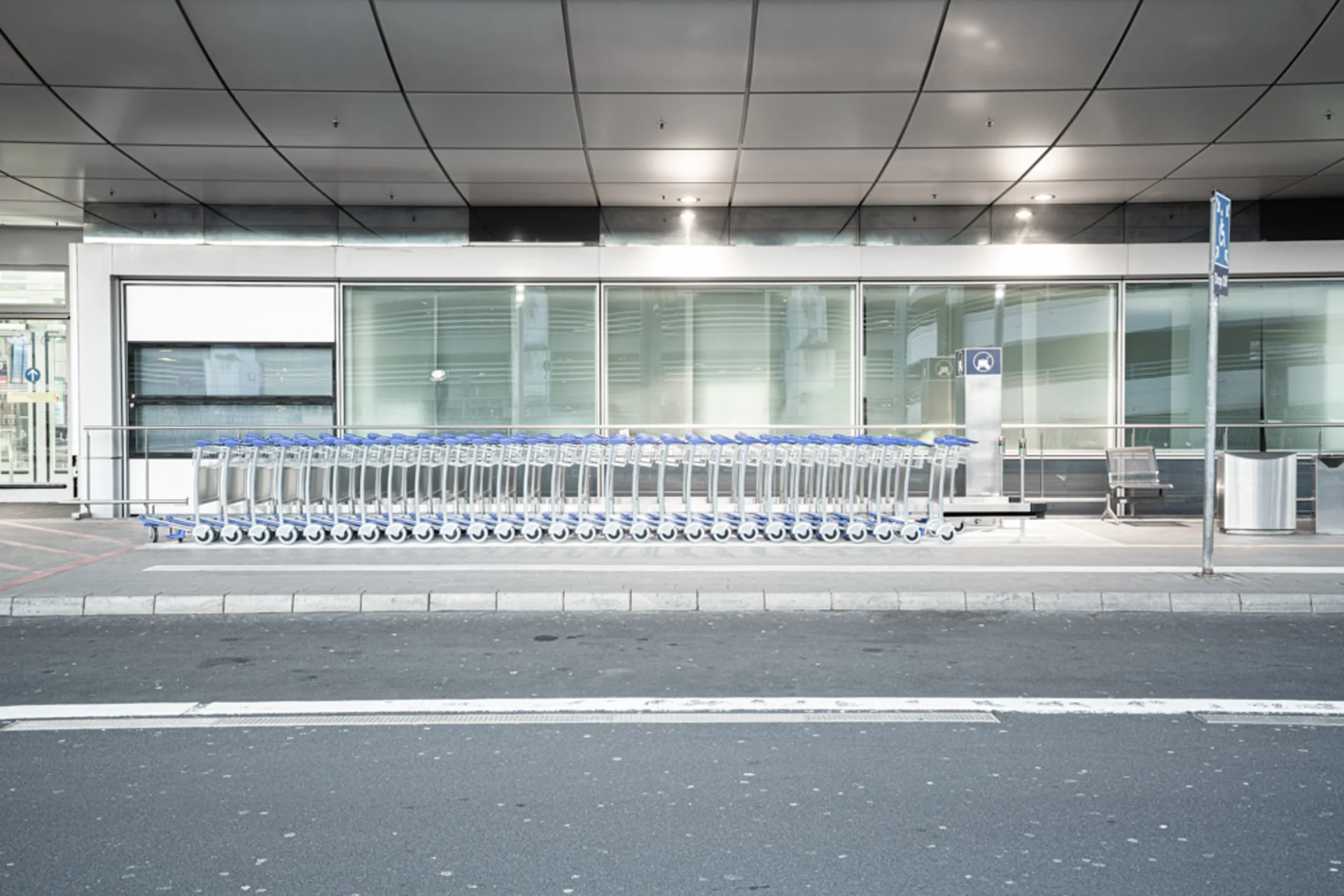 eine Schlange an Einkaufswagen vor einem Gebäude neben einer Straße