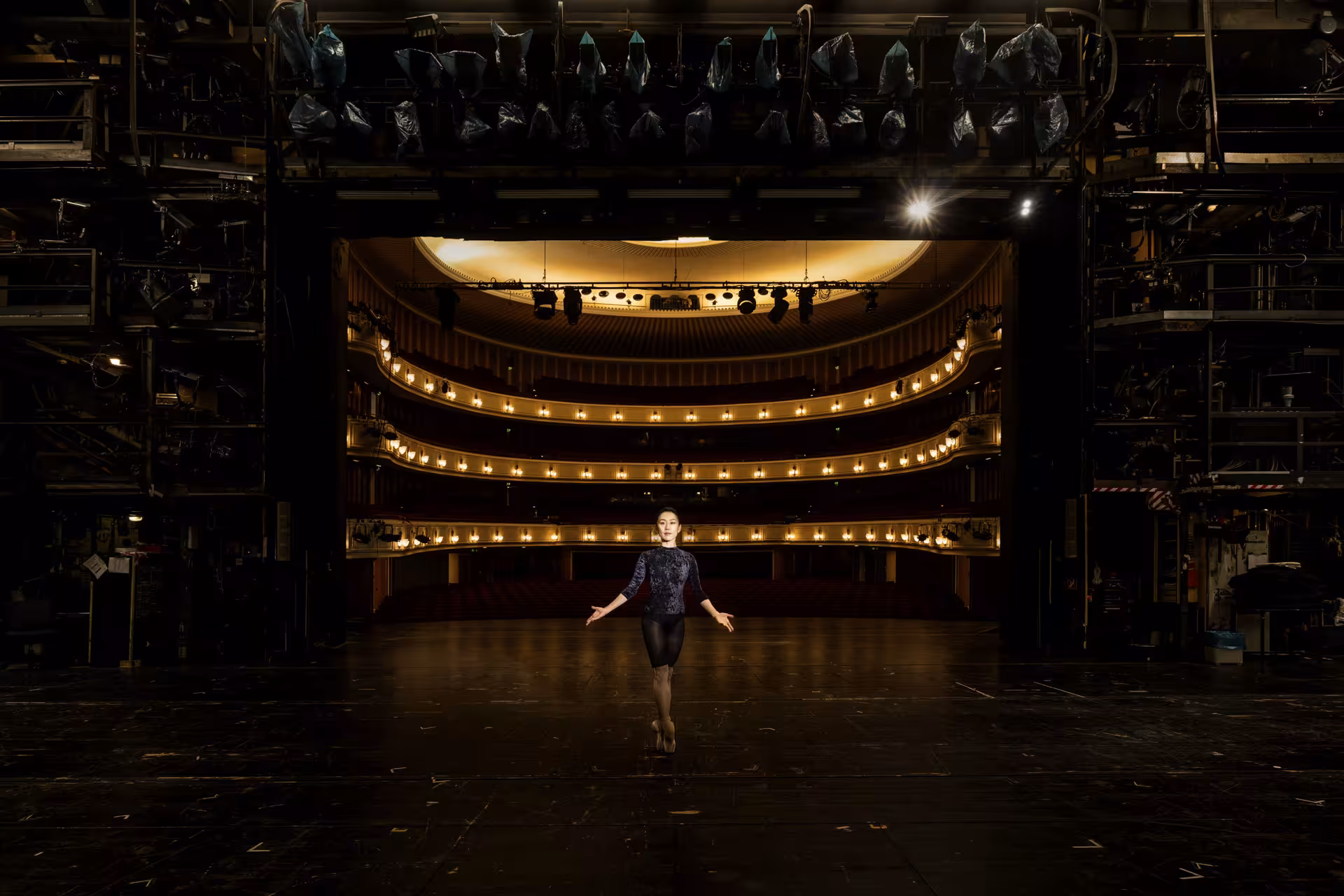 Lichtspot auf Frau in der Mitte einer leeren Oper