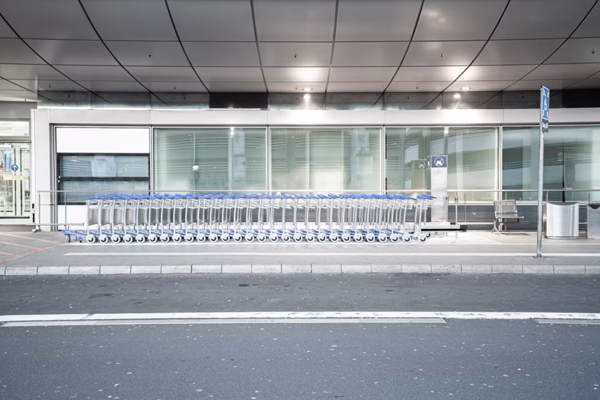 eine Schlange an Einkaufswagen vor einem Gebäude neben einer Straße